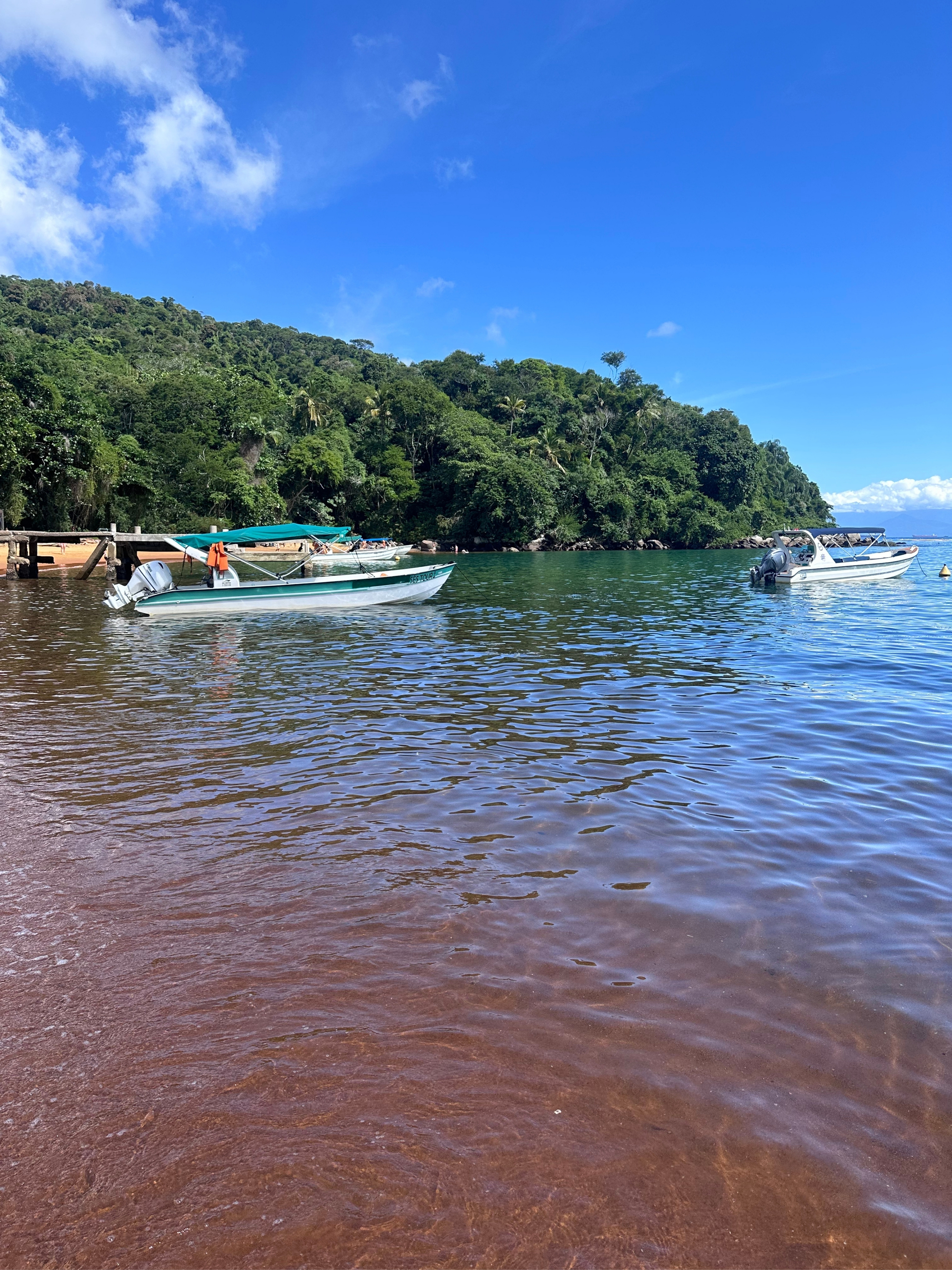Praia de Araçatibinha — arena rojiza y agua calma